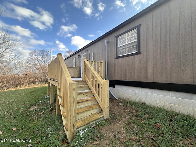 view of side of property with a yard and a wooden deck