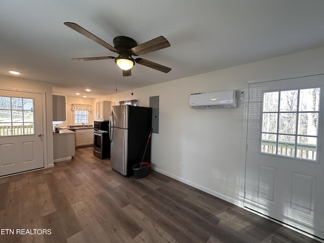 kitchen featuring an AC wall unit, ceiling fan, stainless steel fridge, dark hardwood / wood-style flooring, and white cabinetry