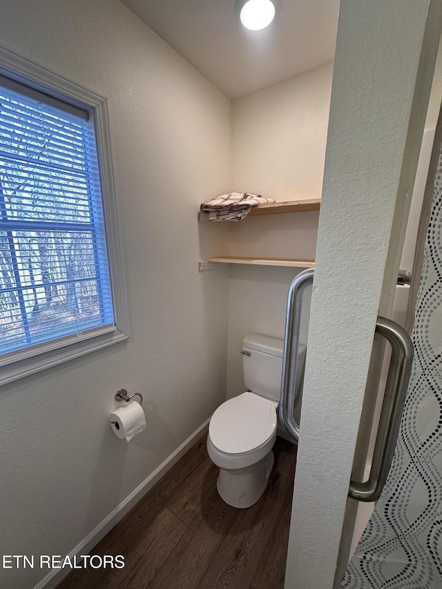 bathroom with toilet, wood-type flooring, and walk in shower