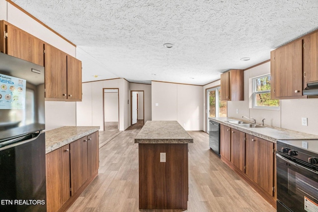 kitchen featuring a center island, light hardwood / wood-style floors, a textured ceiling, and appliances with stainless steel finishes