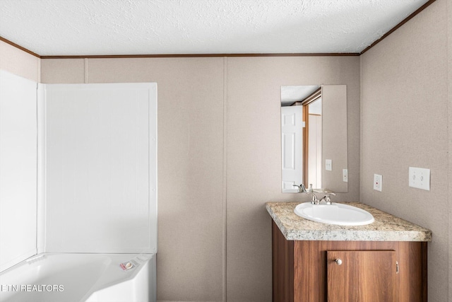 bathroom featuring vanity, a textured ceiling, and ornamental molding