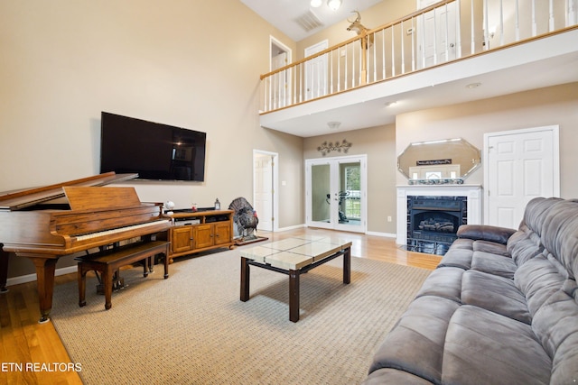 7987 Longmire Rd, Luttrell, TN 37779 - living room featuring a tile fireplace, french doors, a towering ceiling, and light hardwood / wood-style floors