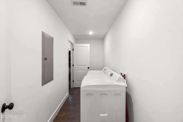 clothes washing area featuring electric panel, washer / clothes dryer, and dark wood-type flooring