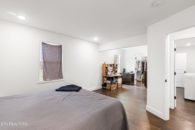 bedroom featuring a walk in closet, a closet, and dark hardwood / wood-style floors