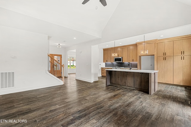 kitchen featuring light countertops, visible vents, stainless steel microwave, a ceiling fan, and dark wood finished floors