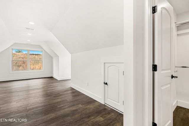 additional living space with lofted ceiling, baseboards, visible vents, recessed lighting, and dark wood-style flooring