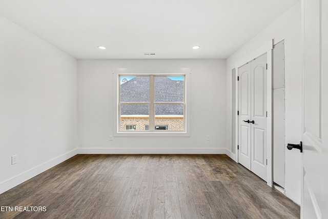 unfurnished bedroom featuring recessed lighting, visible vents, baseboards, and wood finished floors