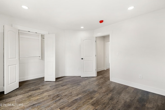 unfurnished bedroom featuring dark wood-type flooring, baseboards, and recessed lighting