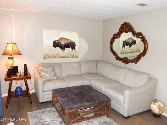 living room featuring dark hardwood / wood-style flooring and wood walls