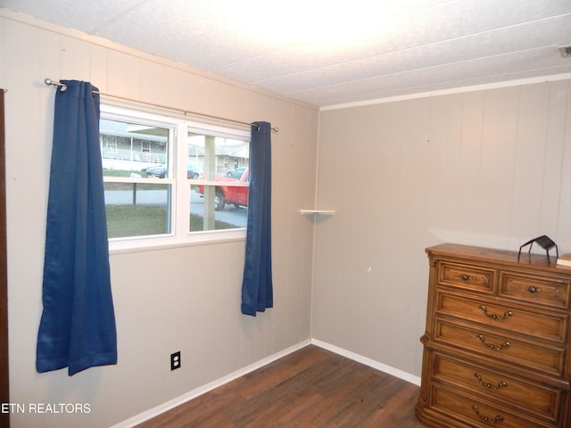 interior space featuring dark hardwood / wood-style flooring and wooden walls