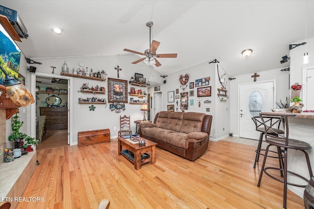 living room with hardwood / wood-style floors, vaulted ceiling, and ceiling fan