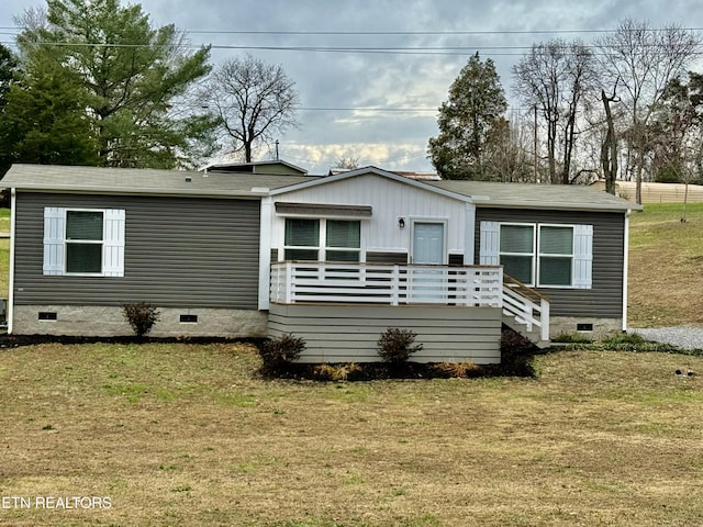 manufactured / mobile home with a wooden deck and a front lawn