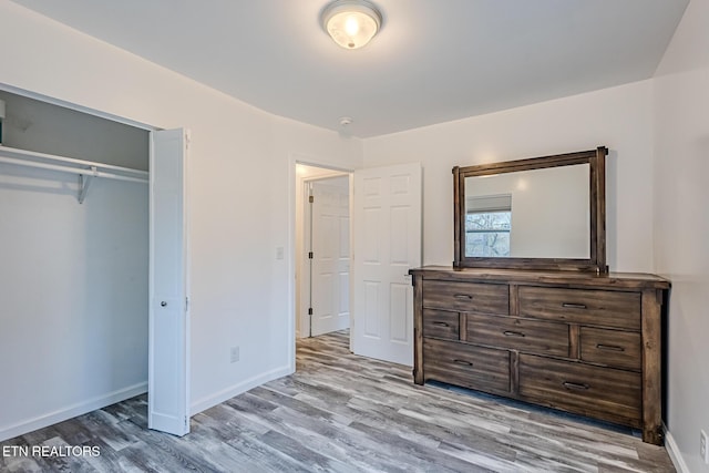 unfurnished bedroom featuring light hardwood / wood-style flooring and a closet