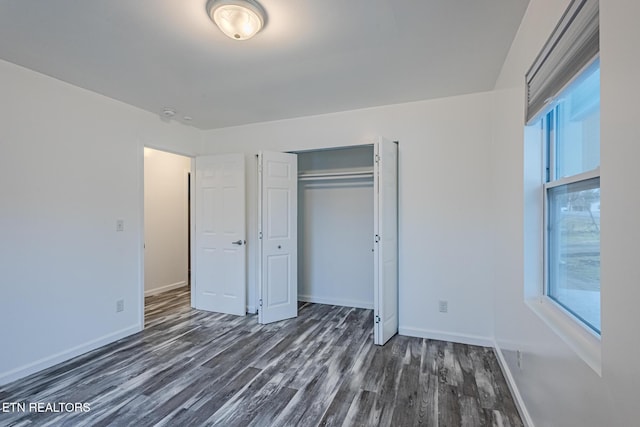 unfurnished bedroom featuring dark hardwood / wood-style flooring and a closet