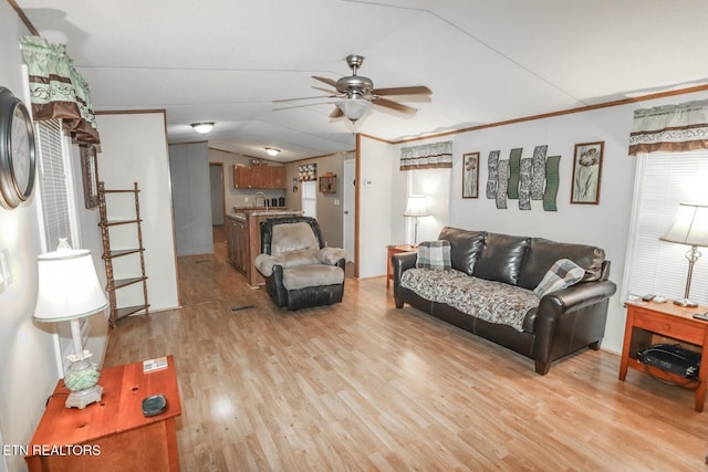 living room with sink, crown molding, vaulted ceiling, ceiling fan, and light hardwood / wood-style floors