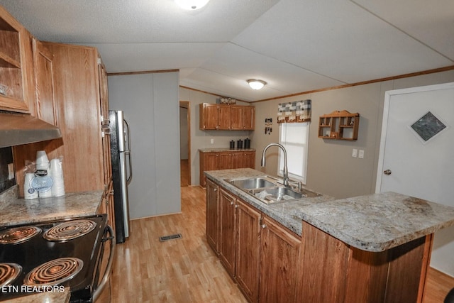 kitchen featuring stove, light wood-type flooring, vaulted ceiling, sink, and a kitchen island