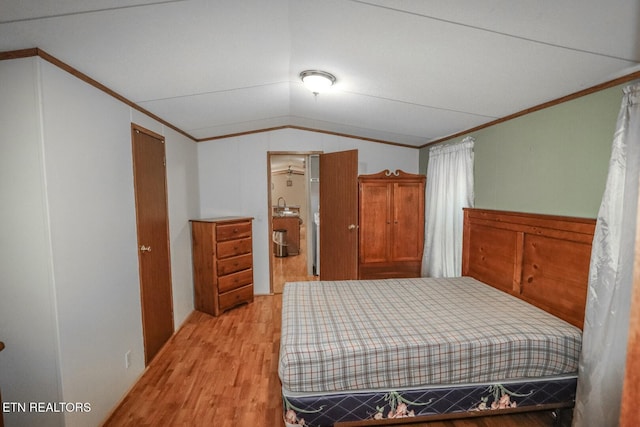 bedroom featuring crown molding, lofted ceiling, and light wood-type flooring