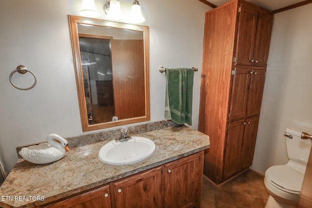 bathroom featuring toilet, vanity, tile patterned floors, and ornamental molding