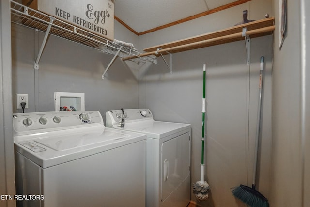 laundry area with a textured ceiling, ornamental molding, and washing machine and clothes dryer