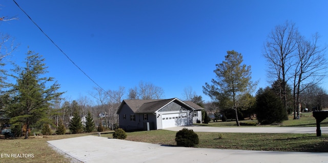 view of home's exterior with driveway, a garage, and a lawn