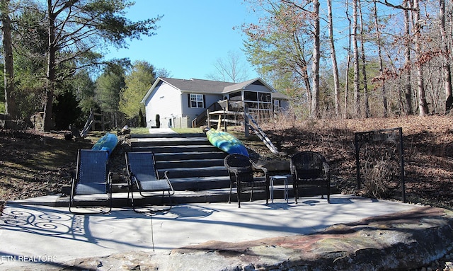 back of property featuring a sunroom and a playground