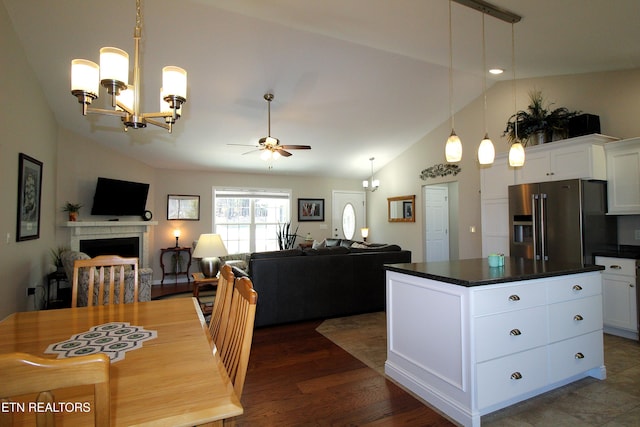 kitchen featuring high quality fridge, dark countertops, white cabinetry, and a center island