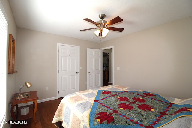 bedroom with ceiling fan, baseboards, and dark wood-style flooring