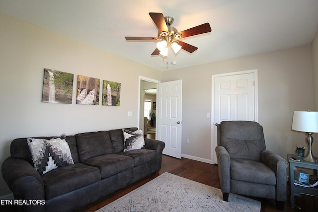 living area featuring dark wood-style floors, ceiling fan, and baseboards