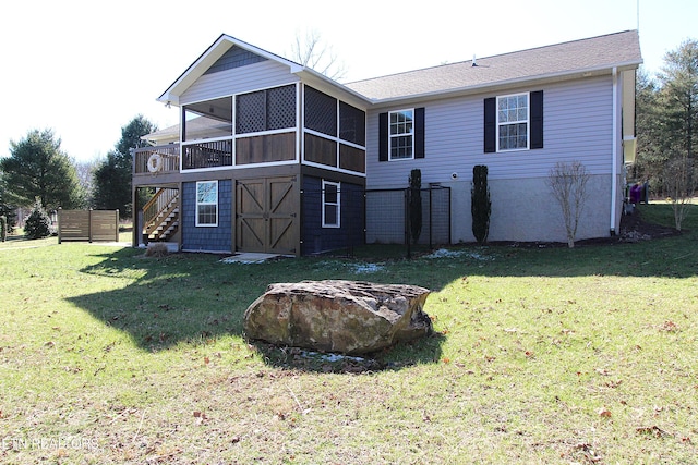 back of house featuring a sunroom, a lawn, and stairway