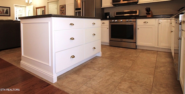 kitchen featuring appliances with stainless steel finishes, dark countertops, and white cabinets