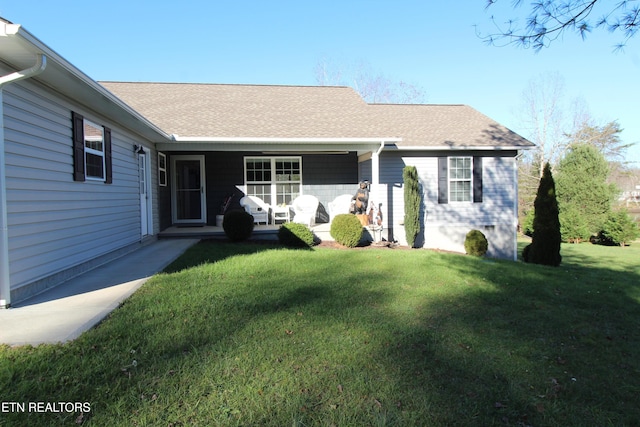 view of front of house with a shingled roof and a front yard