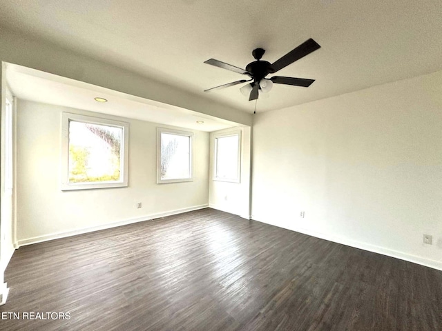 spare room featuring dark hardwood / wood-style floors, plenty of natural light, and ceiling fan