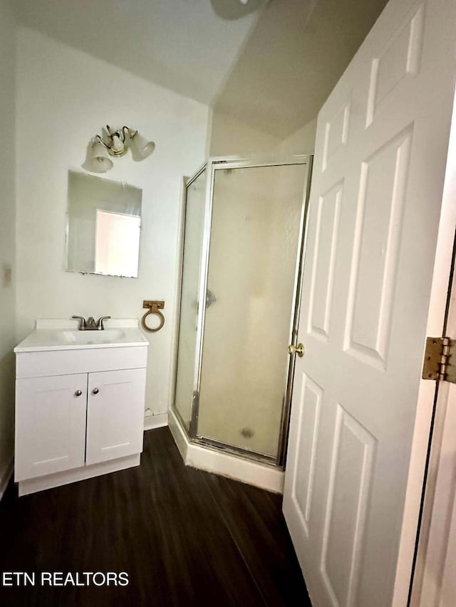 bathroom featuring hardwood / wood-style flooring, vanity, and walk in shower