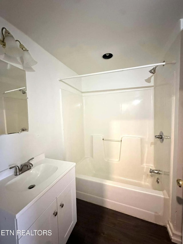 bathroom featuring washtub / shower combination, vanity, and hardwood / wood-style flooring