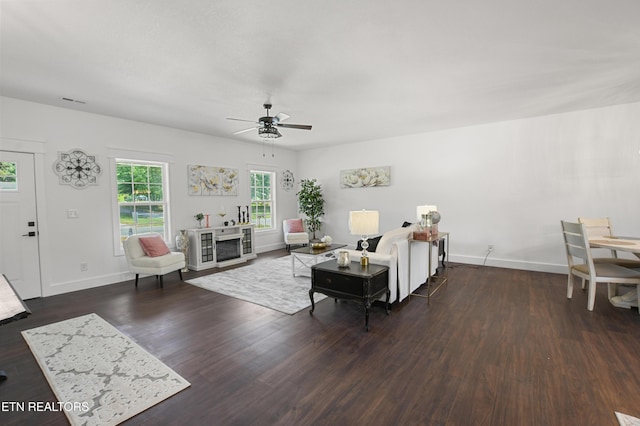 living room featuring ceiling fan and dark hardwood / wood-style flooring