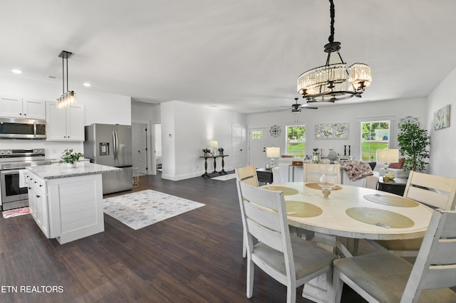 dining area featuring dark hardwood / wood-style floors and ceiling fan with notable chandelier