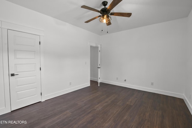 empty room with ceiling fan and dark hardwood / wood-style flooring