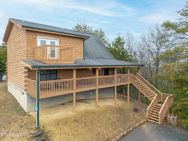 rear view of house with a balcony and a wooden deck