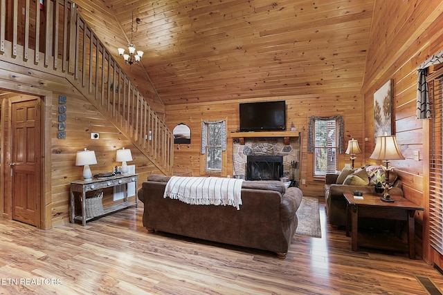 living room with wooden walls, high vaulted ceiling, wood-type flooring, and an inviting chandelier