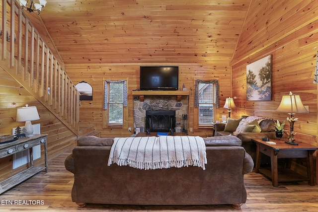 living room featuring wooden walls, plenty of natural light, and hardwood / wood-style flooring