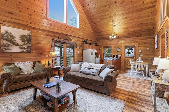 living room featuring high vaulted ceiling, plenty of natural light, and wood walls