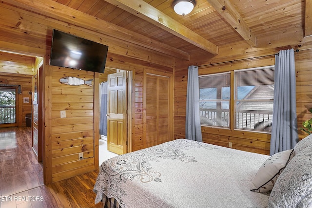 bedroom featuring beamed ceiling, dark hardwood / wood-style flooring, wood ceiling, and wood walls