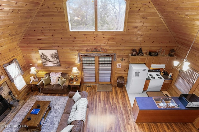 unfurnished living room with wood walls, wooden ceiling, lofted ceiling, light hardwood / wood-style floors, and a chandelier