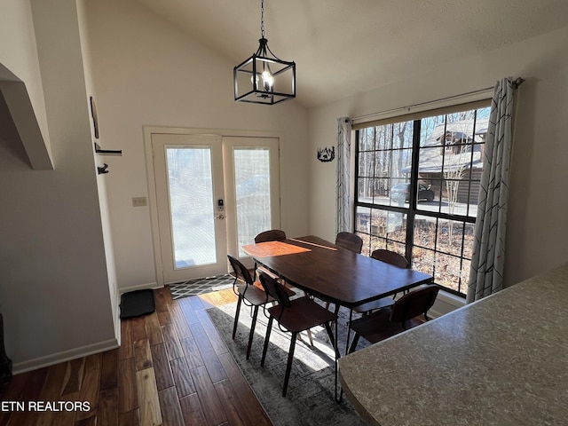 dining room featuring dark hardwood / wood-style flooring, a chandelier, and lofted ceiling