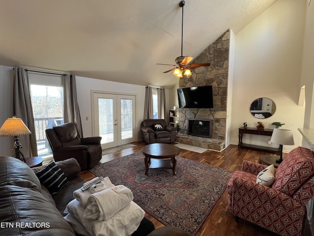 living room with lofted ceiling, french doors, ceiling fan, dark hardwood / wood-style floors, and a fireplace