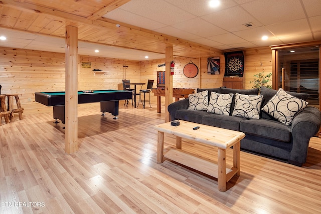 living room with wooden walls, light hardwood / wood-style floors, and pool table