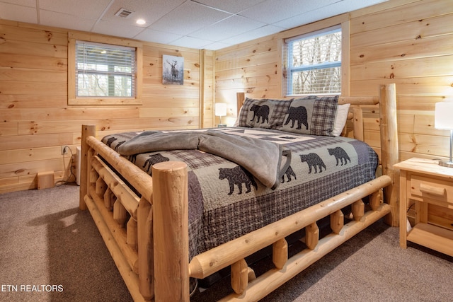 bedroom featuring carpet and wood walls