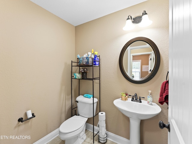 bathroom featuring tile patterned flooring, toilet, and sink