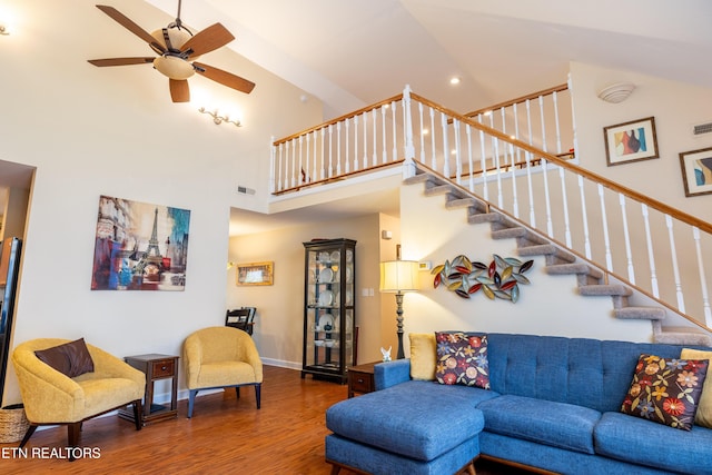 living room with ceiling fan, wood-type flooring, and high vaulted ceiling