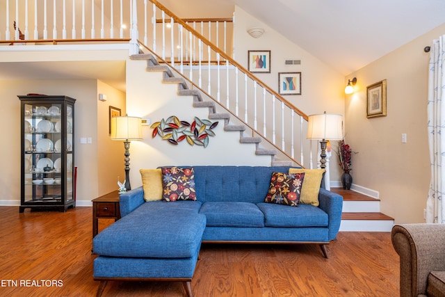 living room featuring high vaulted ceiling and wood-type flooring